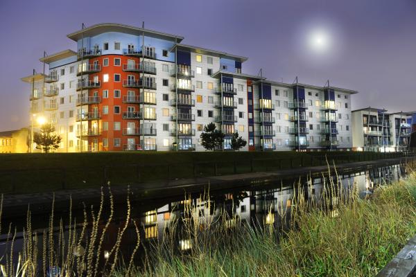 New development of flats overlooking a canal at night time