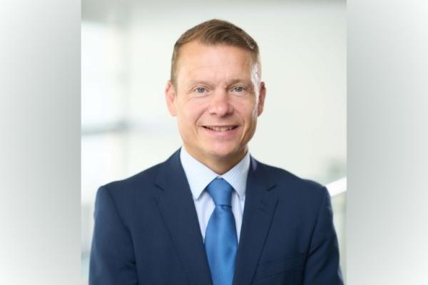 James Norris, wearing a blue suit and tie
