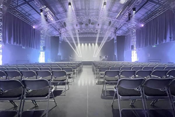 Interior of Walsall Arena, view of stage with spotlights from behind seats