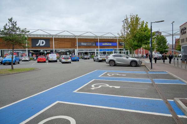 Retail units viewed from a car park with accessible spaces