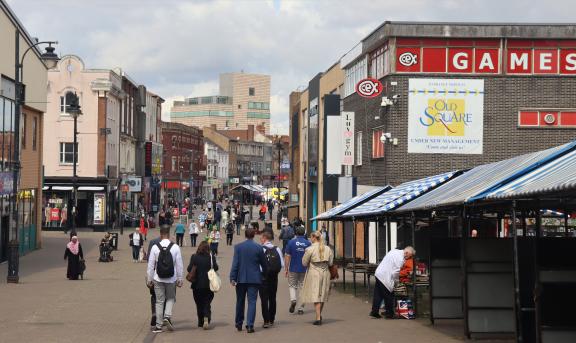 Pedestrians in Walsall town centre with New Art Gallery in background