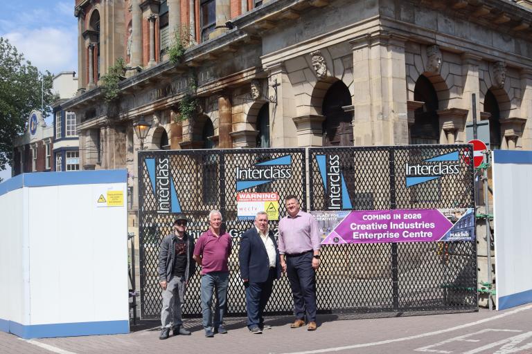 Four people standing outside The Guildhall during renovation works
